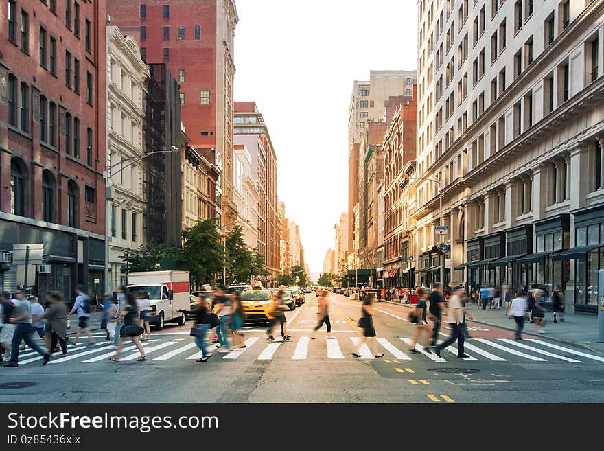 Crowds of people walking through a busy crosswalk at the intersection of 23rd Street and Fifth Avenue in Midtown Manhattan, New