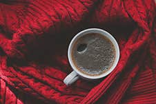 Coffee Top View. Black Coffee In A White Mug On Red Sweater Background. Winter Time Concept. Stock Images