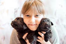 Girl Holding And Hugging Two Of The Puppies Are Black In Color Is Happy And Smiling Stock Photography