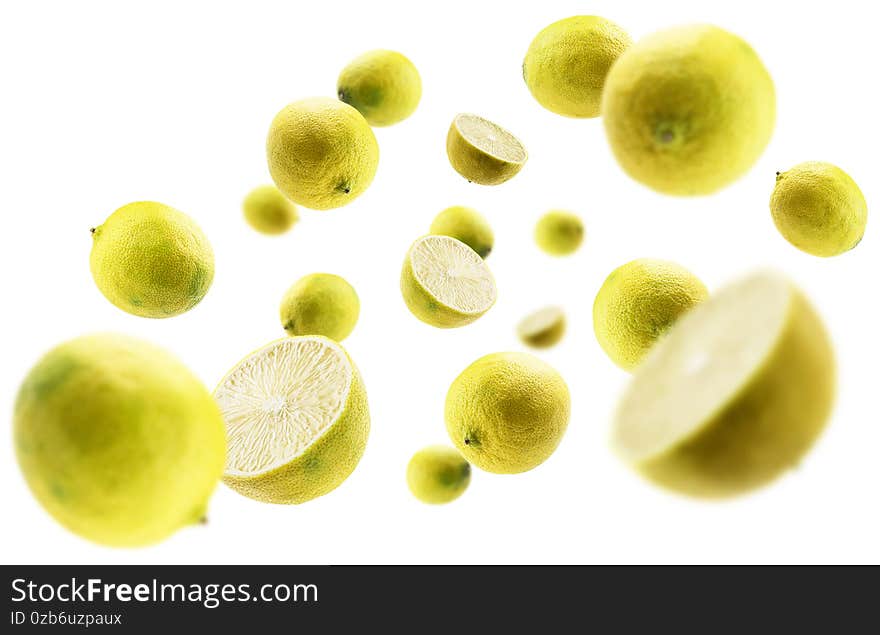 Yellow limes levitate on a white background