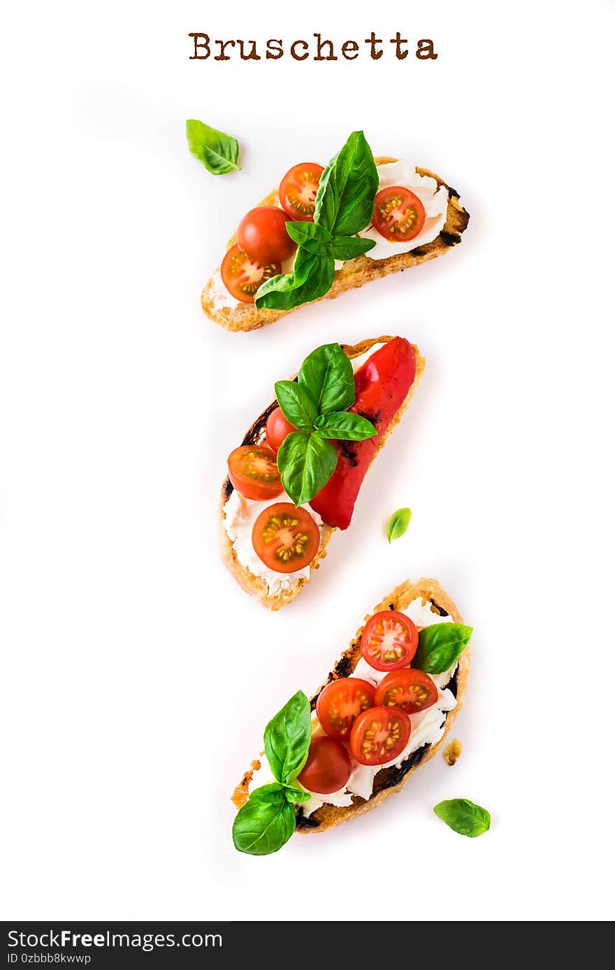 Bruschetta sandwiches with tomatoes, cream cheese, grilled paprika and basil isolated on white background, top view, copy space. Traditional italian snack - grilled bruschetta toasts