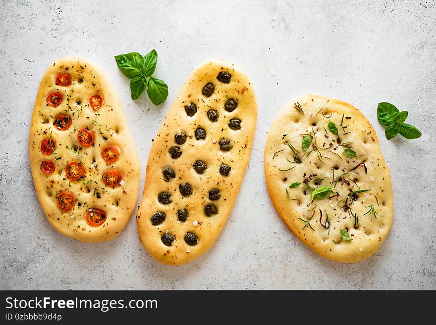 Italian Focaccia Bread with various vegetable filling. Fresh baked focaccia with tomatoes, olives, garlic and herbs, top view, copy space