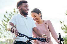 Vietnamese Woman And African American Man Taking A Bike For Rent Royalty Free Stock Images