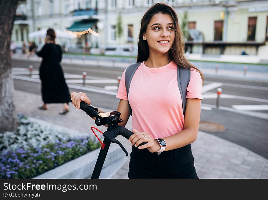 Young beautiful woman riding an electric scooter.