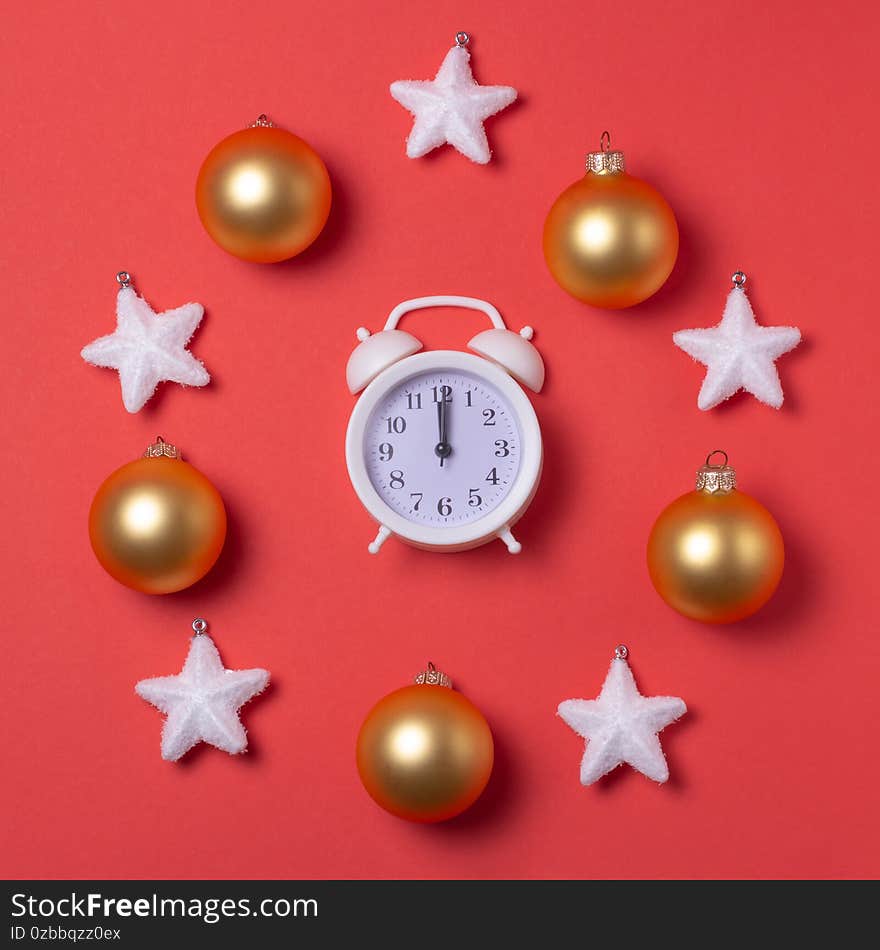 New year`s circular composition of a clock in the center, snow-white stars and Golden toys on a red background.