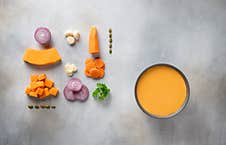 Dark Bowl With Pumpkin Soup With Seeds, Spices And Parsley On Gray Background Stock Photo