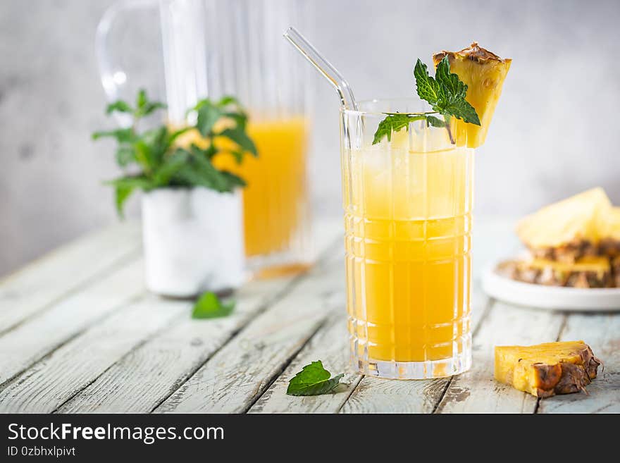 Fresh pineapple cocktail in the glass with ice and mint, summer drink