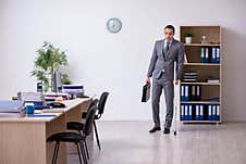 Young Leg Injured Male Employee Working In The Office Royalty Free Stock Photo