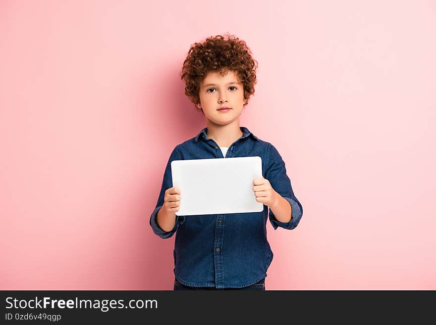 Boy in denim shirt holding digital