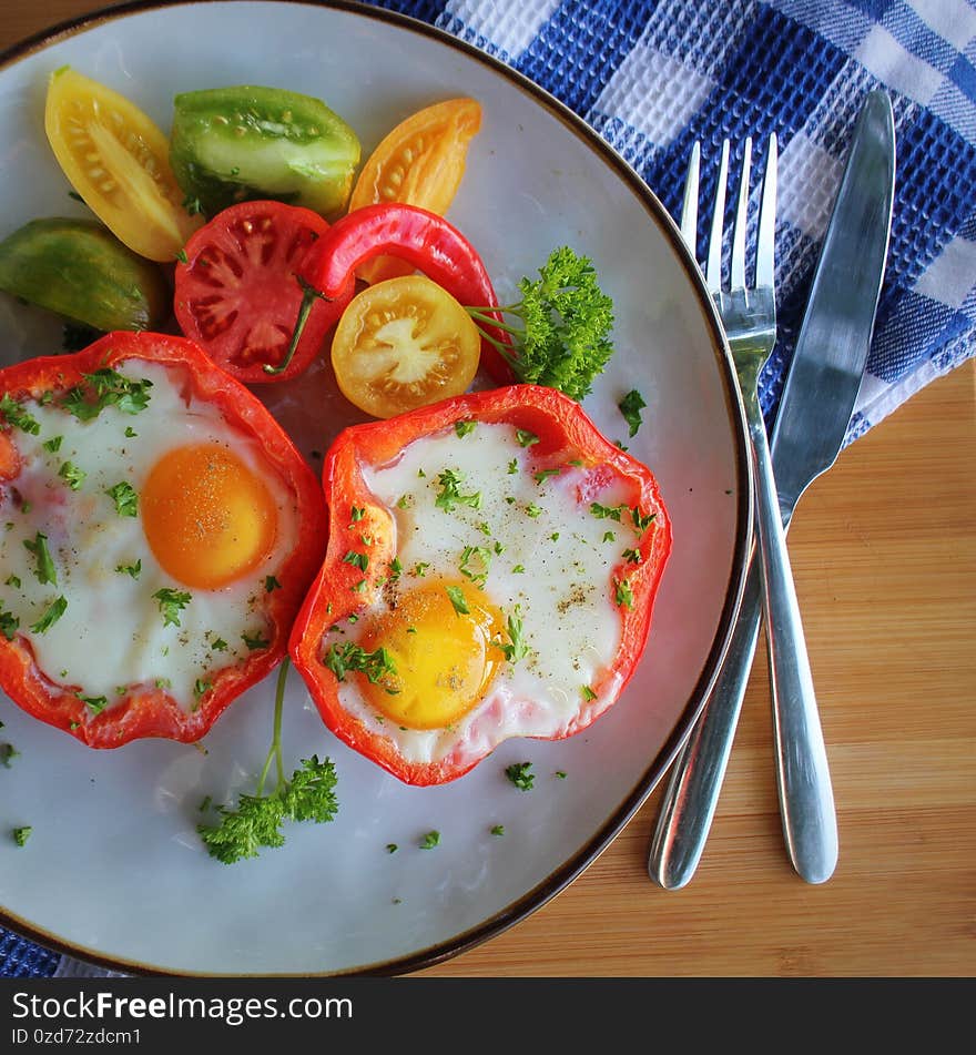 Fried egg in the ring of the bell peppers with herbs