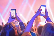 Teenagers Recording Video Of Live Music Concert With Smartphone - Back View Royalty Free Stock Images