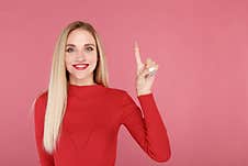 Young Happy Model Pointing Up By Finger  Over The Pink Background. Royalty Free Stock Images