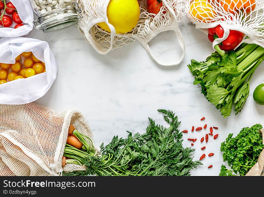 Stylish composition on the marble table with zero waste bags, nuts, seeds, eggs, bio vegetables and eco fruits.