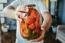 Canning, Male Hands Hold A Jar Of Tomatoes Stock Photo