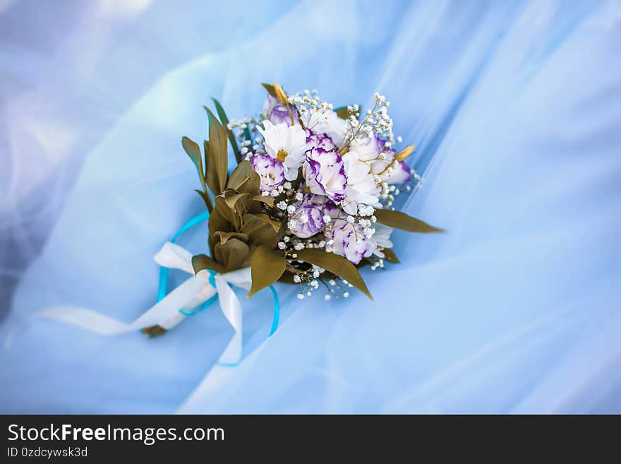 Wedding bouquet of eustomas and chrysanthemums on a blue tulle background