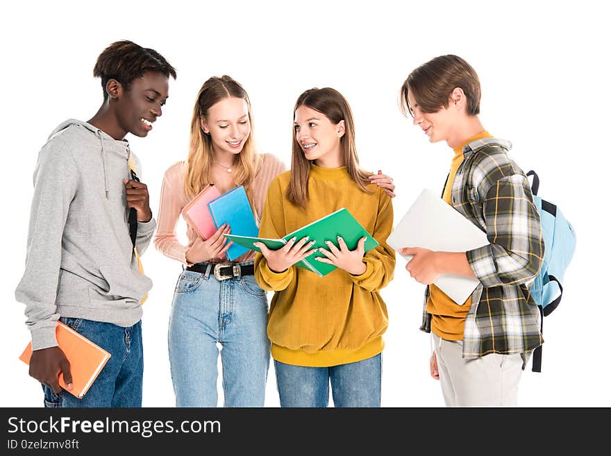 Multicultural teenagers with laptop, books and