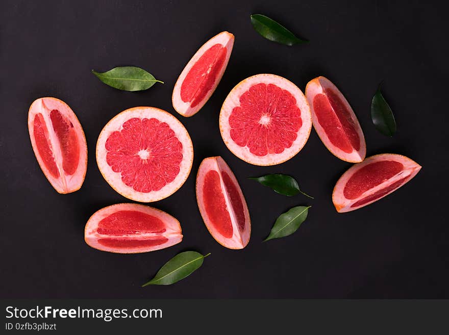 Grayfruit slices on a black background. Flat lay.