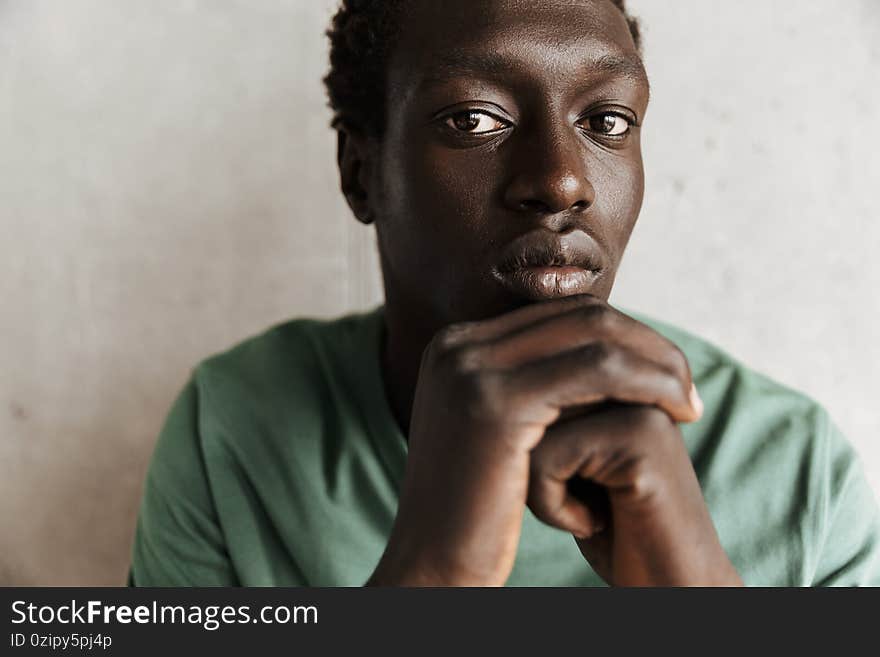 Image of african american man looking at camera while standing over wall