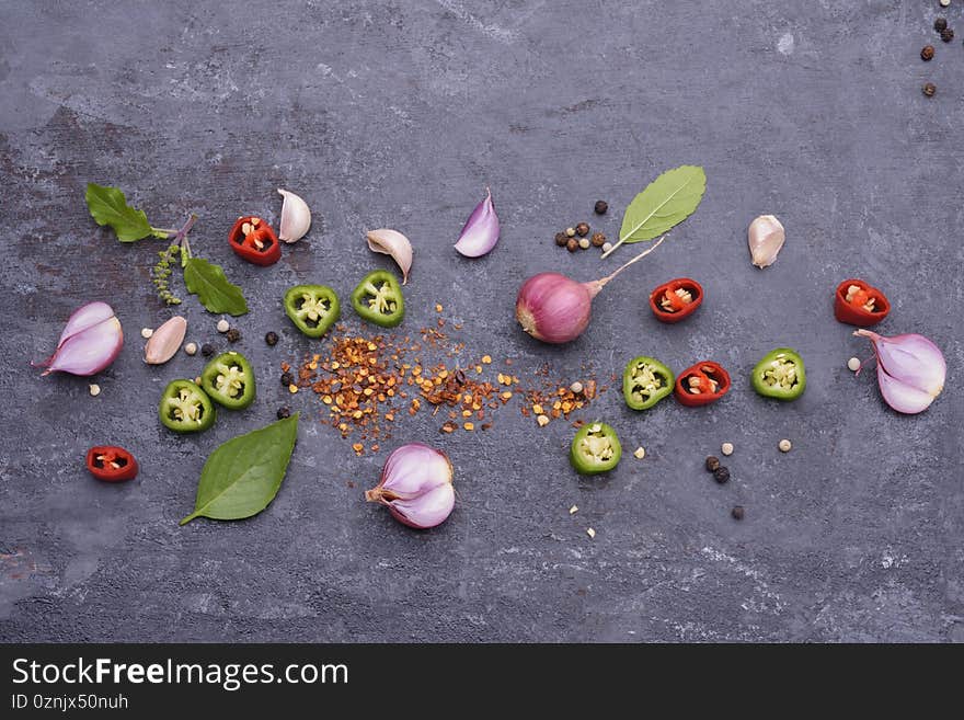 Red chili basil garlic Pepper and spices Placed on a black wooden table - top view