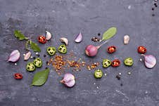 Red Chili Basil Garlic Pepper And Spices Placed On A Black Wooden Table - Top View Stock Photos