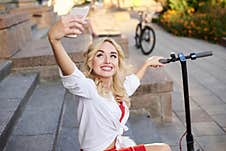 Young Blond Woman, Sitting On Staircase Of Old Historical Building In City Center, Taking Picture With Her Phone. Traveler Royalty Free Stock Images