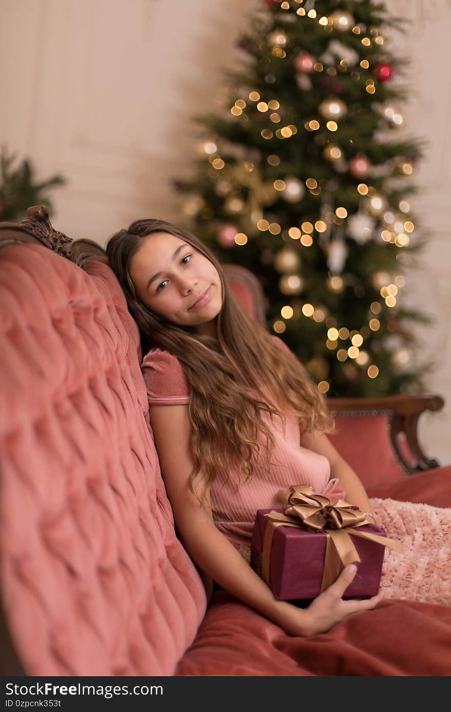 Gorgeous girl with a holiday christmas present in a stylish interior