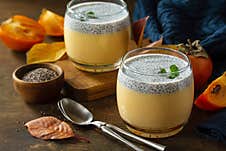 Autumn Dessert. Homemade Panna Cotta With Persimmon Fruit And Chia Seeds On A Wooden Table. Royalty Free Stock Photo