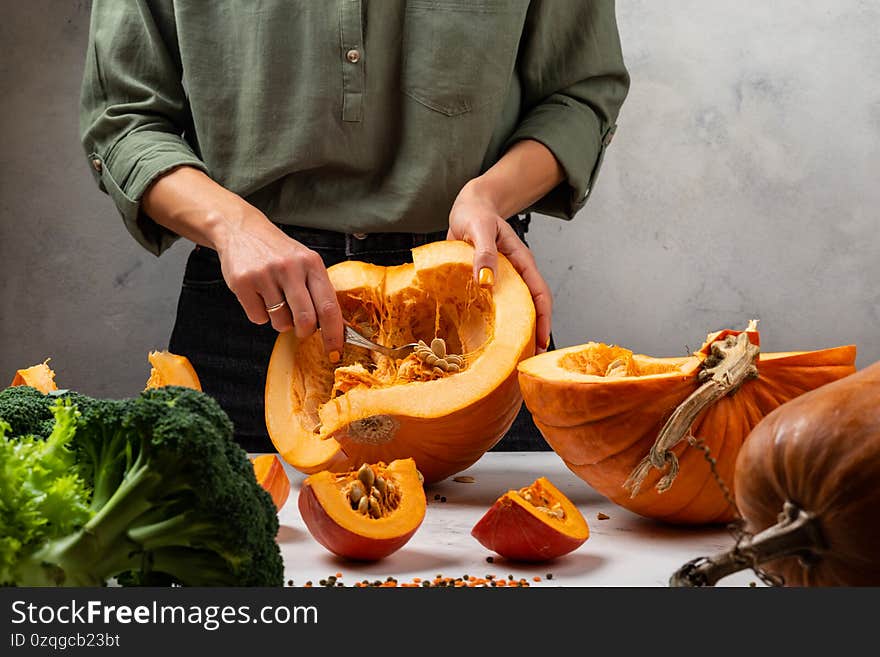 Woman peels and prepare pumpkin on the kitchen. Close-up