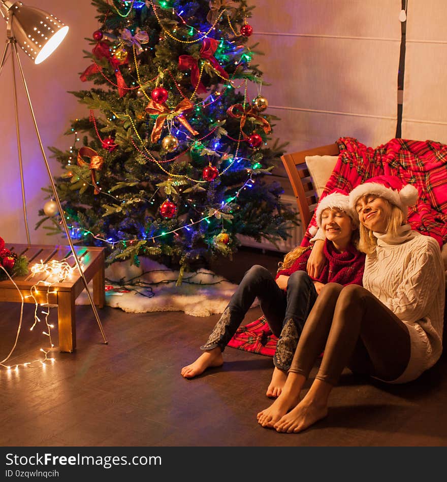 Smiling girl with mom near christmas tree at home