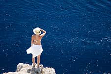 A Girl In A White Dress Stands On A Rock Stock Photography