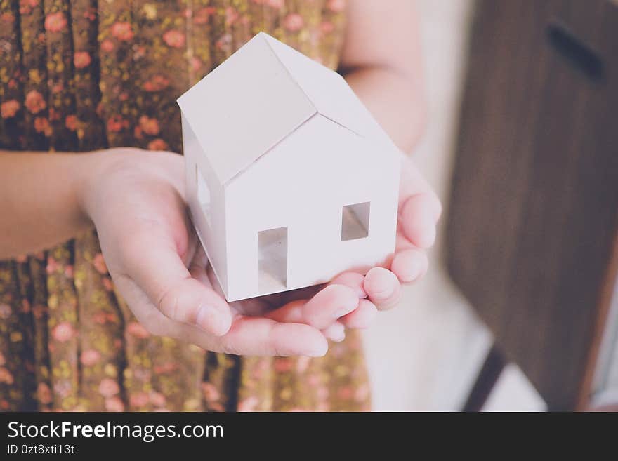 Girl holding little home for happy family concept