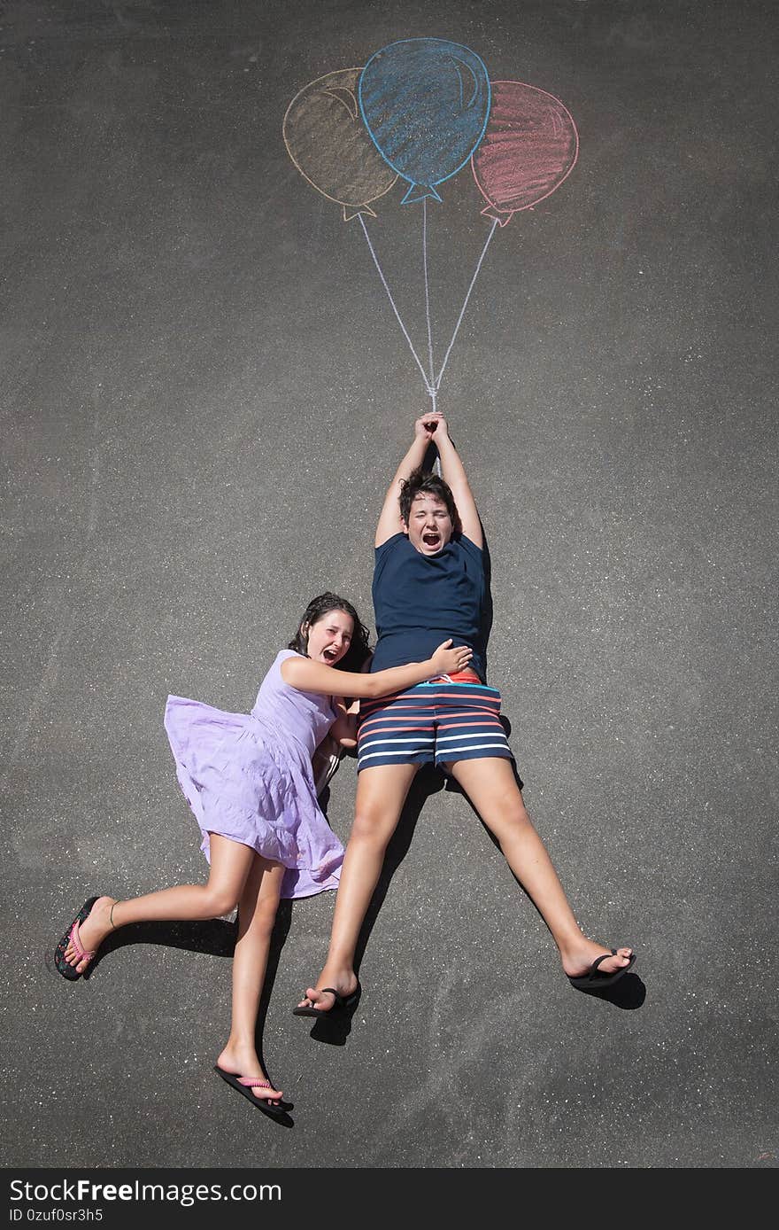 Young kids playing with chalk drawn balloons. Young kids playing with chalk drawn balloons