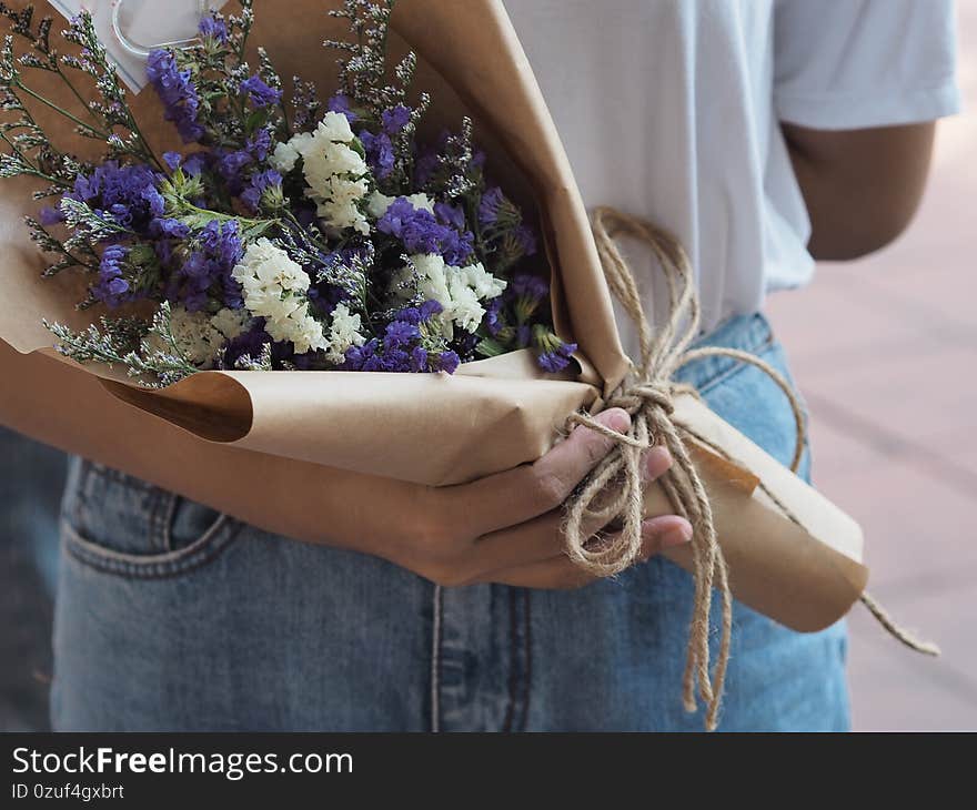 Closeup Statice, Sea lavender, marsh rosemary, white and purple color a bouquet of flowers in a woman hand