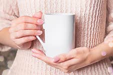 Mockup - White Cup In The Hands Of Woman In A Pink Winter Sweater. Christmas Coffee Mug Stock Photos