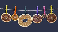 Dried Pieces Of Different Citrus Fruits Hang On Colored Clothespins Stock Photo