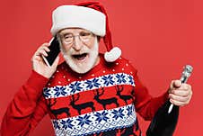 Senior Man In Santa Hat Talking Royalty Free Stock Image