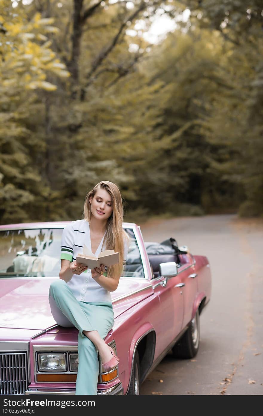 Smiling woman sitting on hood of