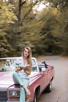 Smiling Woman Sitting On Hood Of Royalty Free Stock Photography