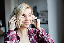 Blonde Woman In Checkered Shirt Putting Stock Photos