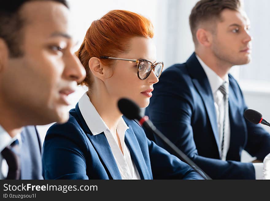 Redhead female politician in eyeglasses, sitting