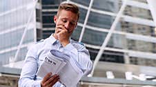 Businessman Reading Newspaper Feeling Serious Standing In Urban Background. Handsome Men Holding Newspaper In His Hand With Stock Photos