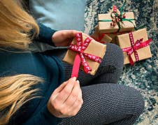 Close Up On Woman Opening Christmas Present Box With More Gifts On Background Stock Images