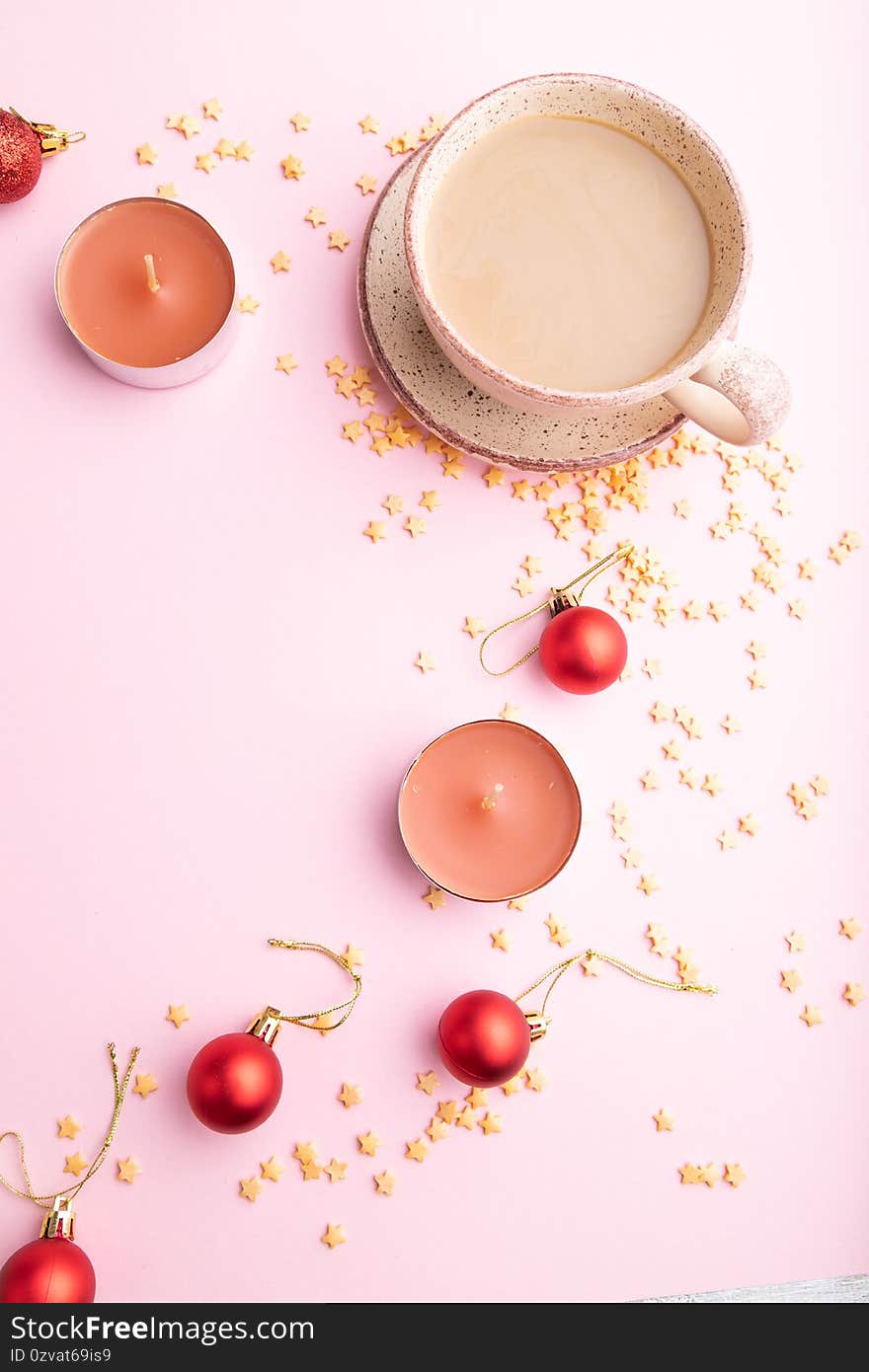 Christmas or New Year composition. Decorations, red balls, cup of coffee, on a pink paper background. Top view, copy space, flat lay