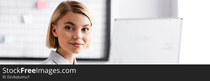 Cheerful young businesswoman smiling at camera, banner