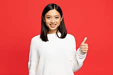 Asian Woman In Sweater Showing Thumb Stock Photo