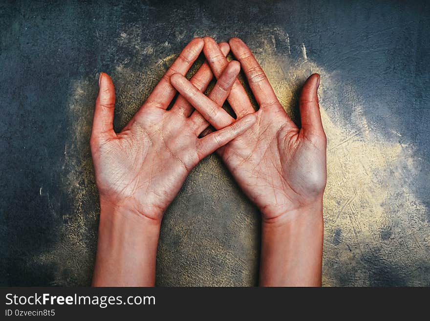 Open palms up of the girl`s hands in sequins on a dark background