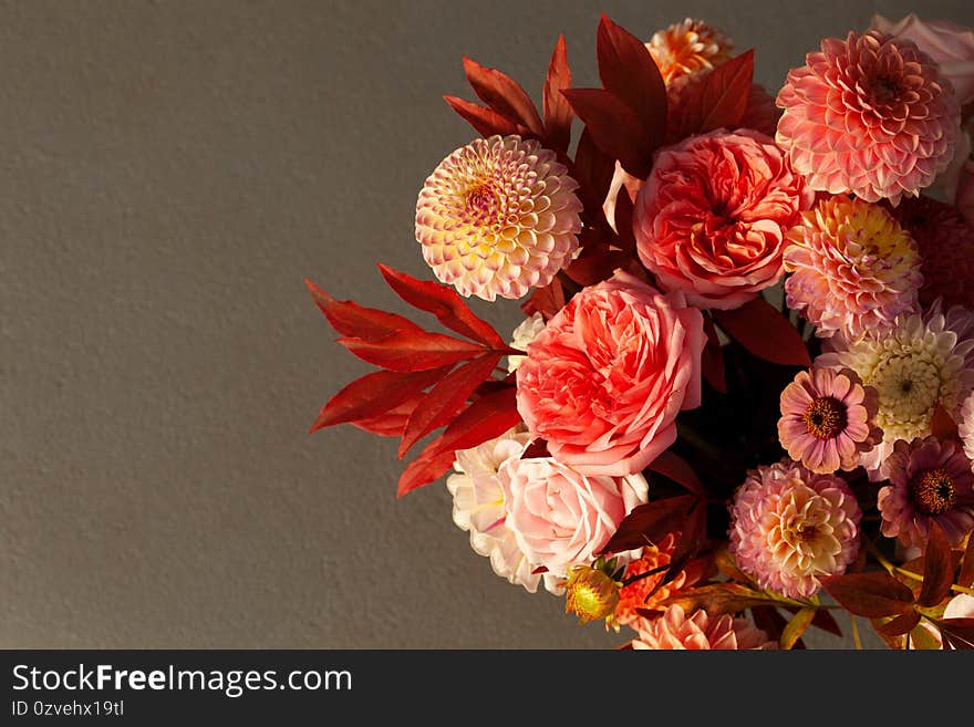 Floral composition of dahlia flowers, roses and autumn leaves.