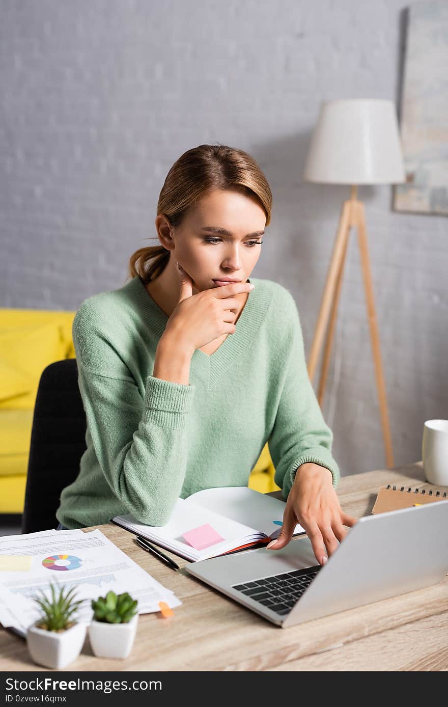 Freelancer using laptop while working near