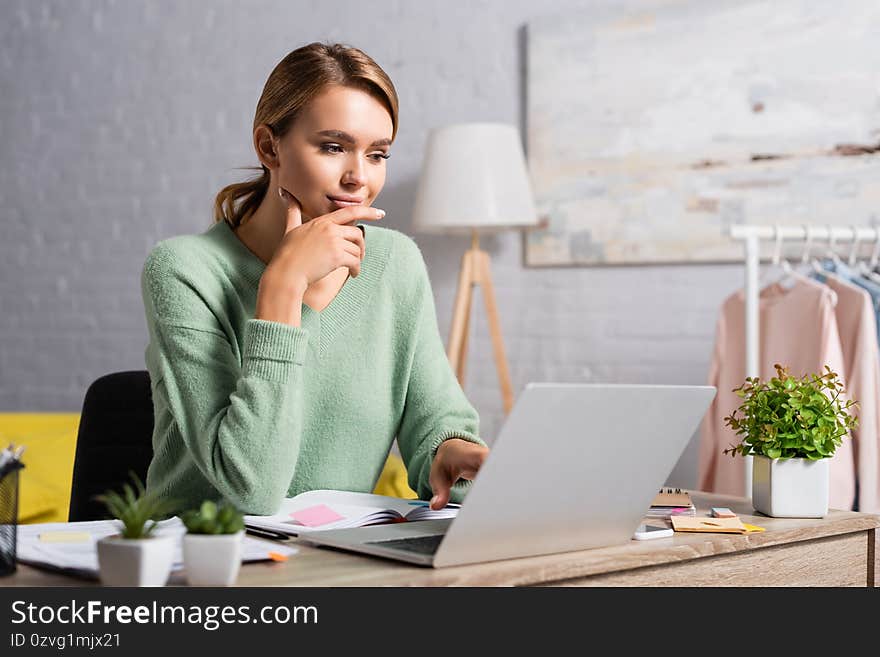 Freelancer using laptop while working near