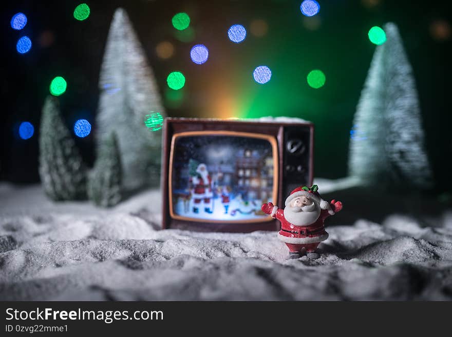 Creative Christmas concept. Vintage television set on snow with Santa Claus. Artwork decoration. Creative Christmas concept. Vintage television set on snow with Santa Claus. Artwork decoration